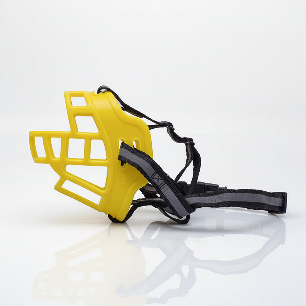 Yellow dog muzzle with black strap on a white background
