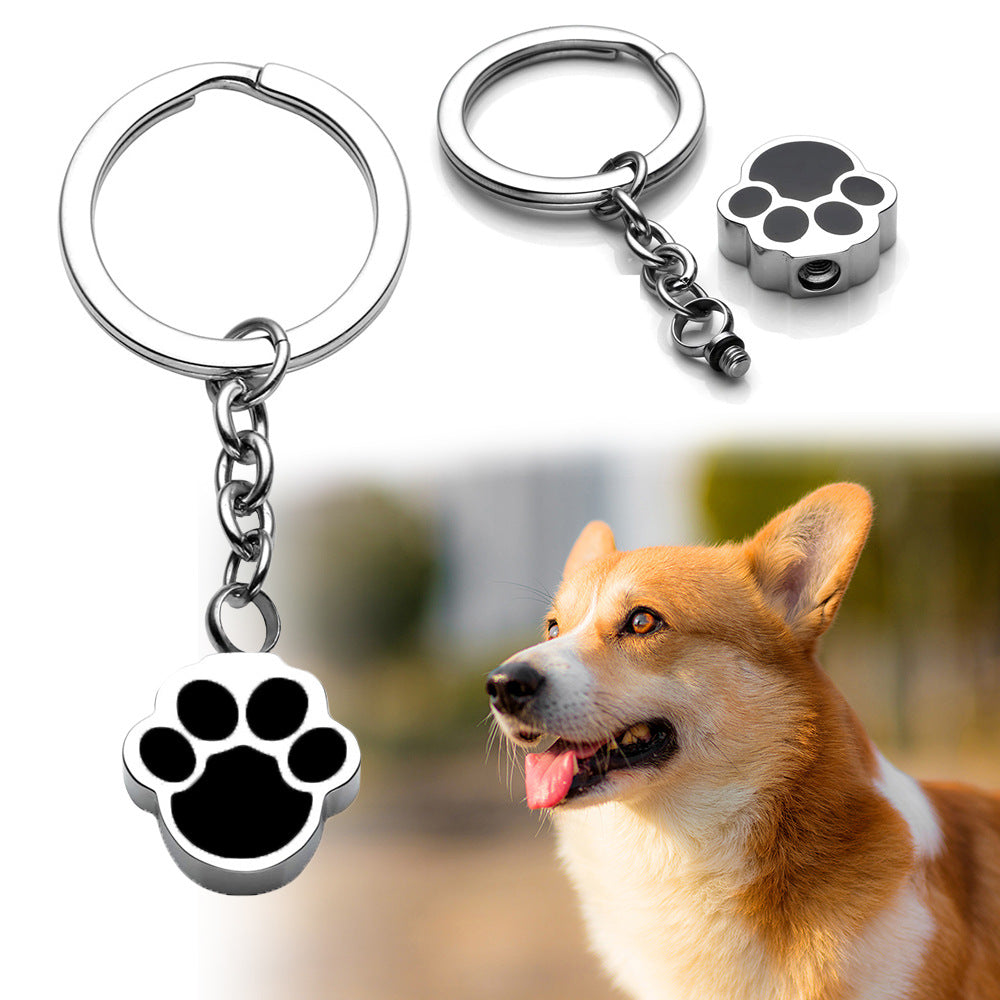 Keychain with paw charm and a dog in the background