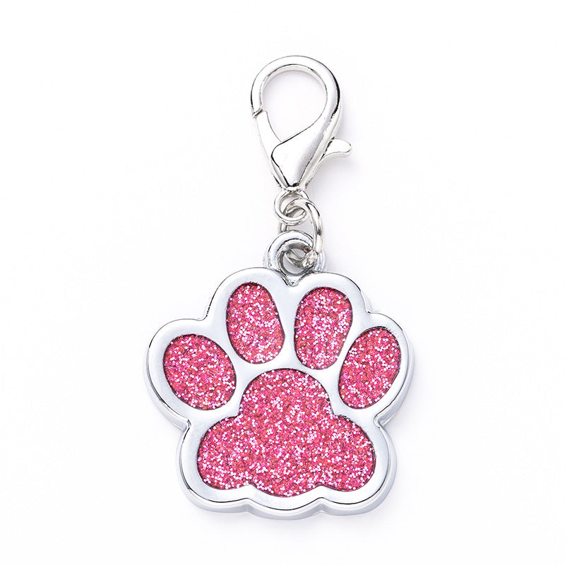 Pink glitter paw print charm on a white background