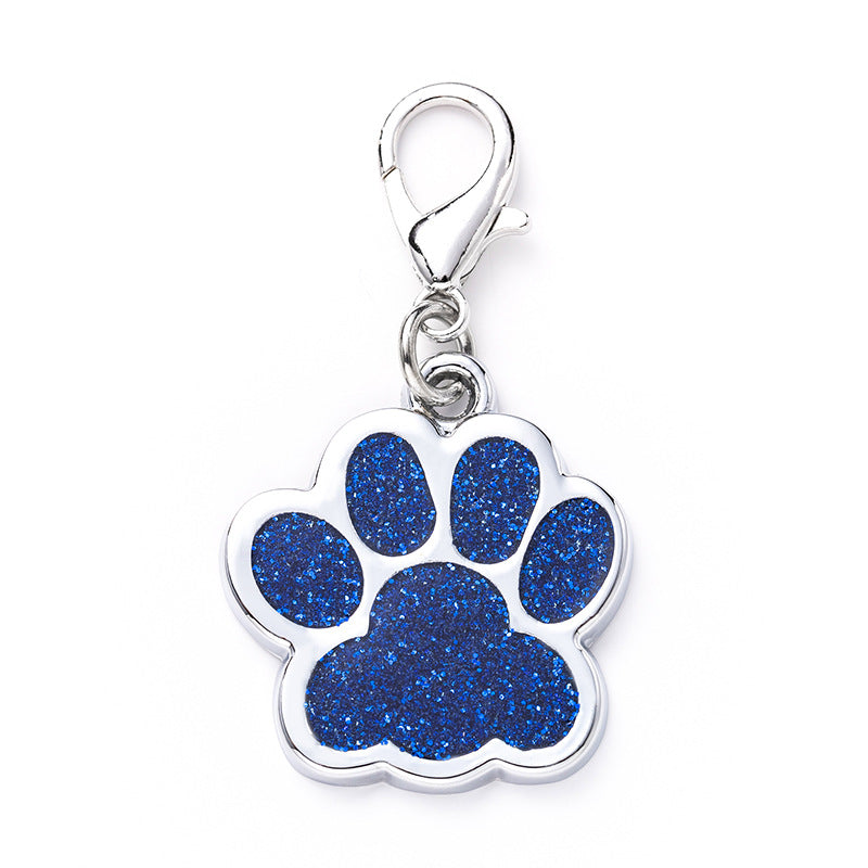 Paw print charm with blue glittery center on a white background