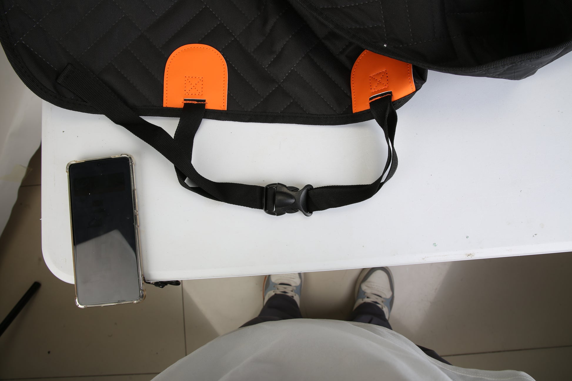Black saddle with orange accents on a white surface, viewed from above.