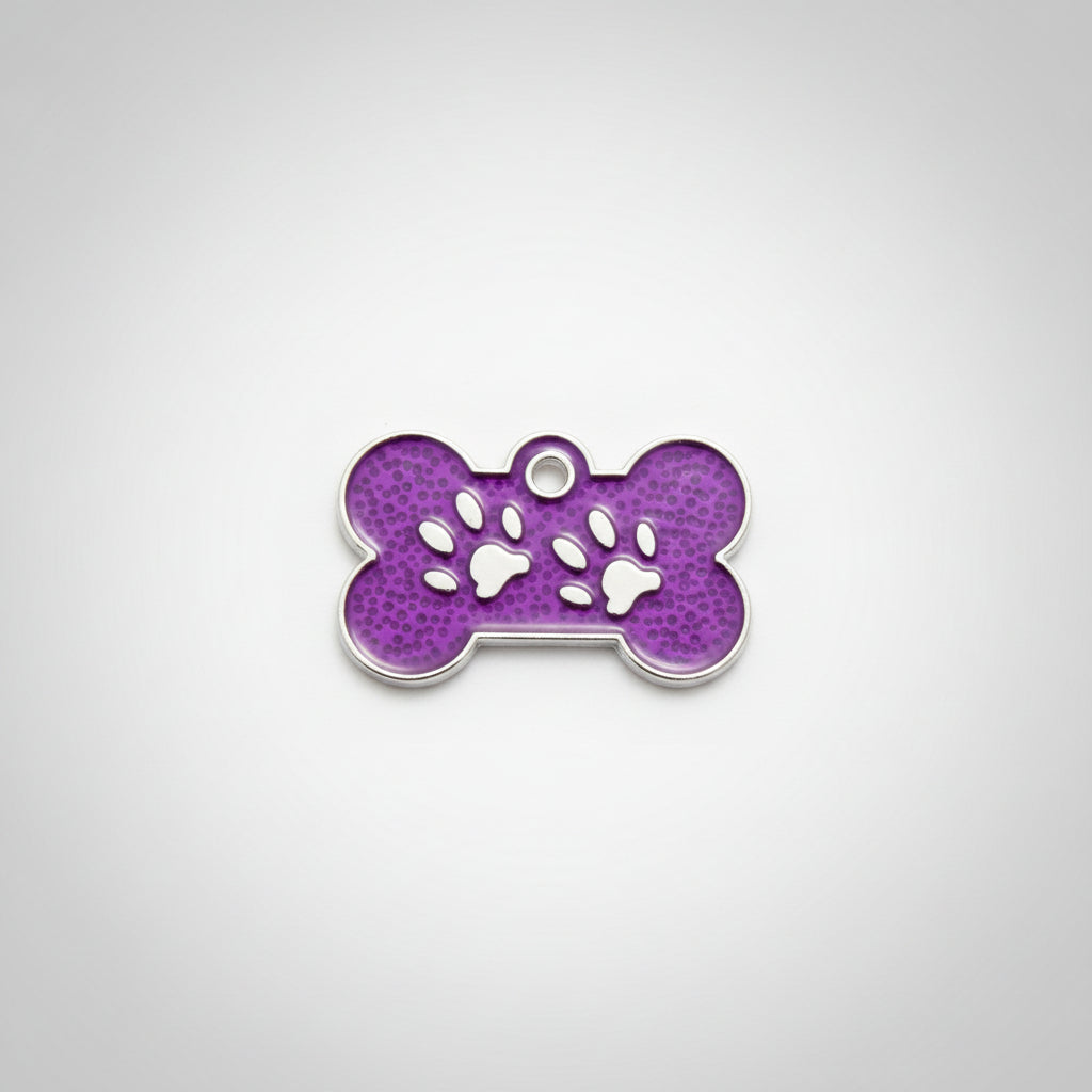 Purple bone-shaped pet tag with paw prints held in a hand