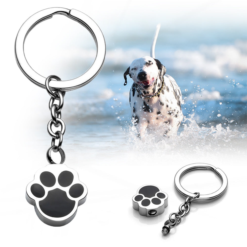 Paw print keychain with a dog running in water in the background