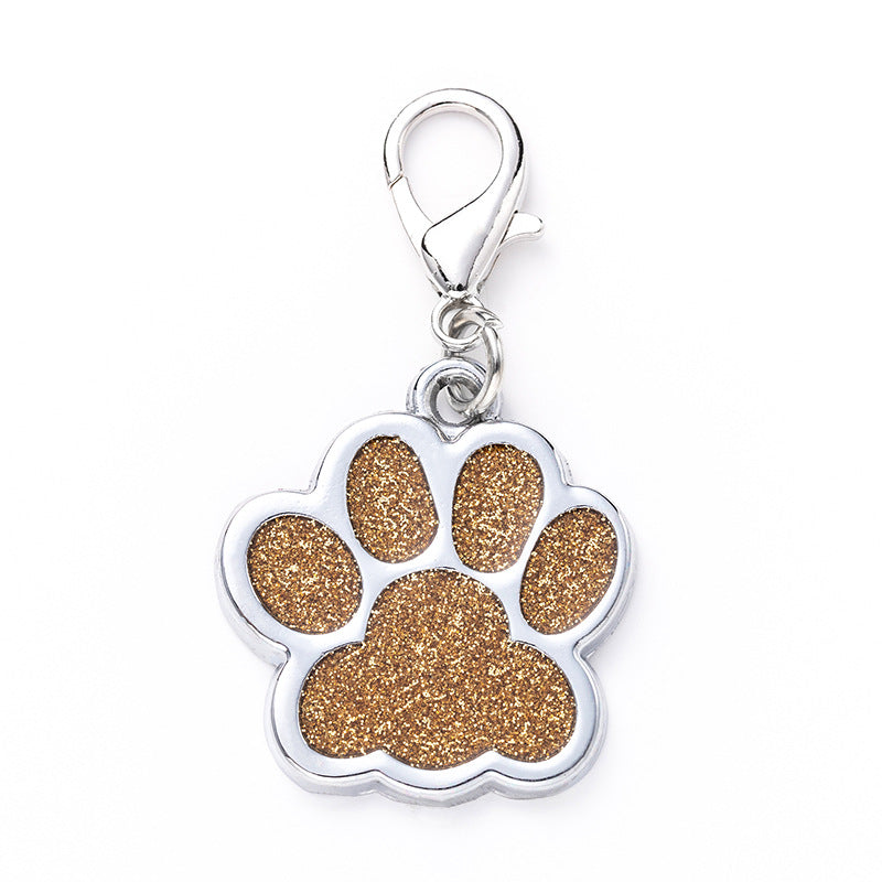 Paw print charm with gold glitter on a white background